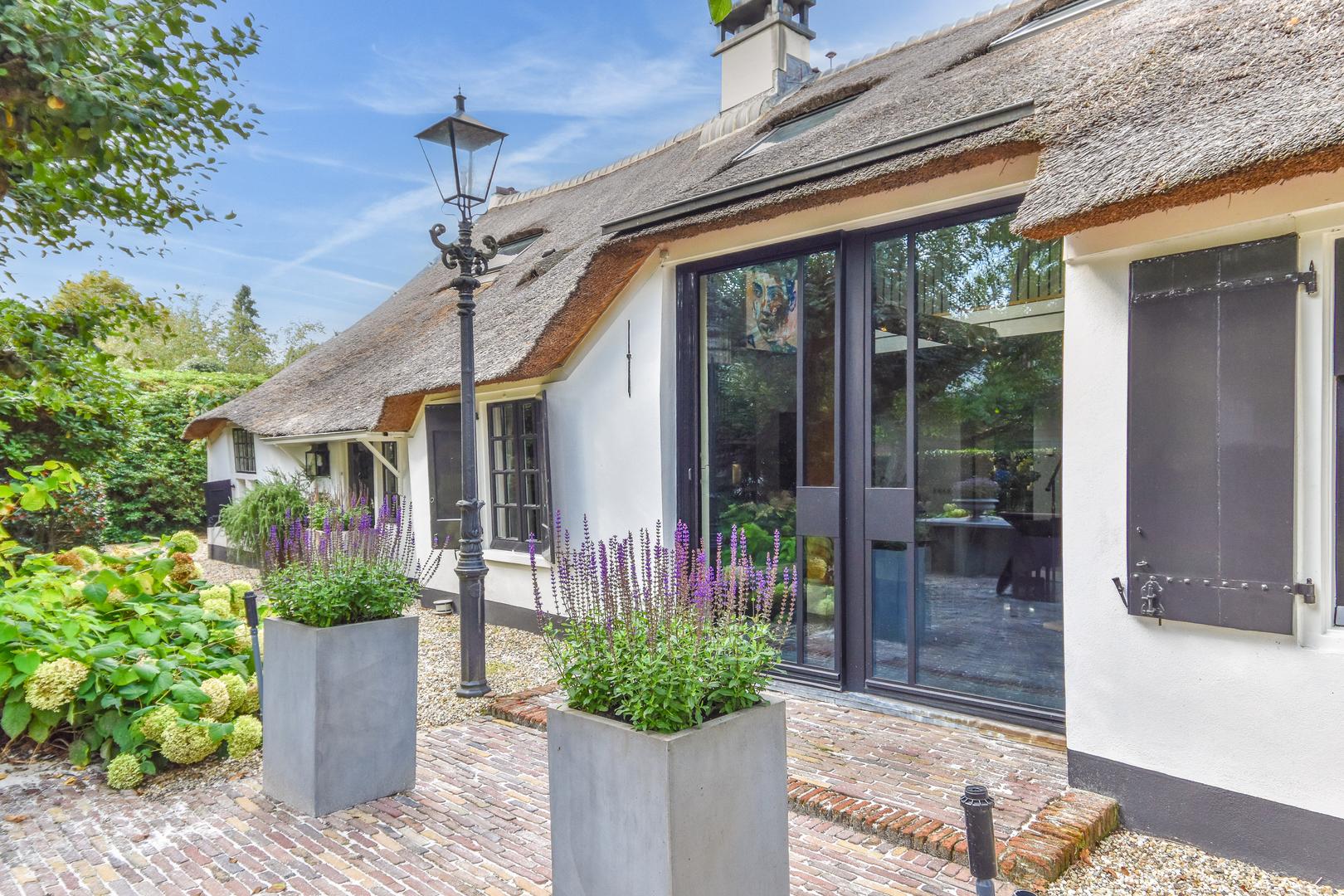 Rietgedekte boerderij aan de tuinzijde